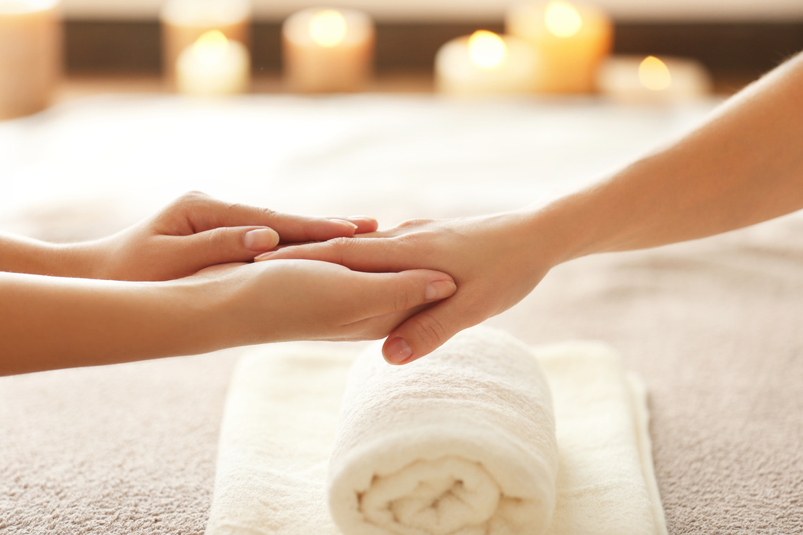 Hands Massaging a Person's Hand Up Close